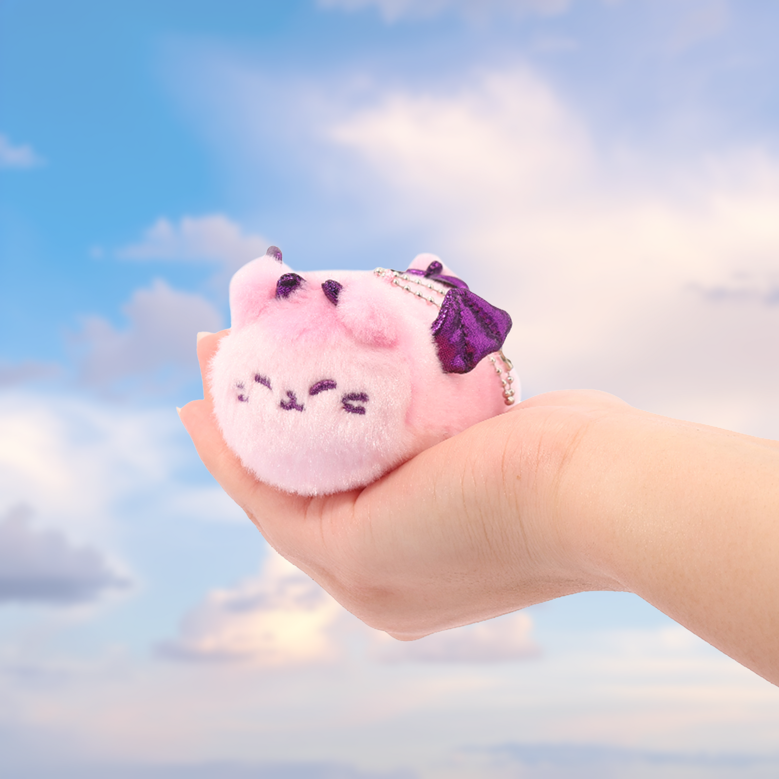 Anirollz Dragon Treasure mini plush keychain held in hand to show size — pink dragon cat charm